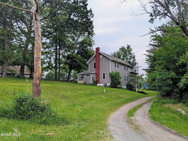 225 Mickel Ln, Duncansville, PA 16635 - view of home's exterior featuring a chimney, dirt driveway, and a lawn
