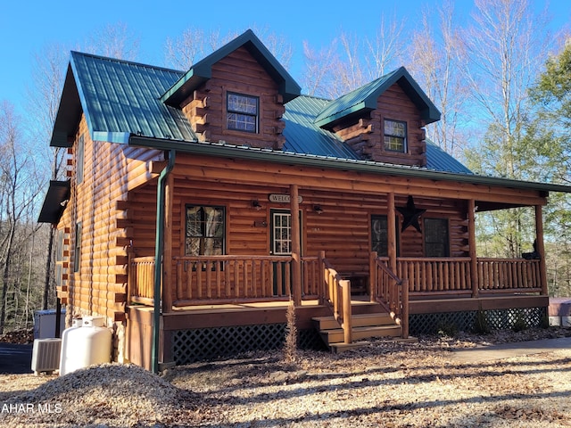 log home featuring log siding, metal roof, and a porch