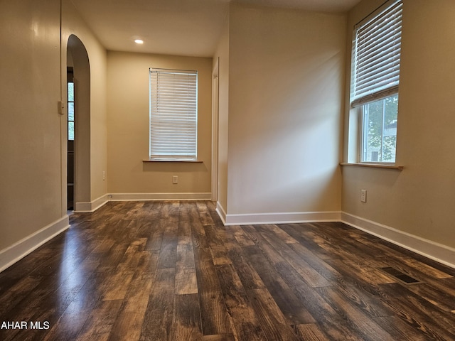 413 10th St, Altoona, PA 16602 - empty room featuring arched walkways, dark wood-type flooring, and baseboards