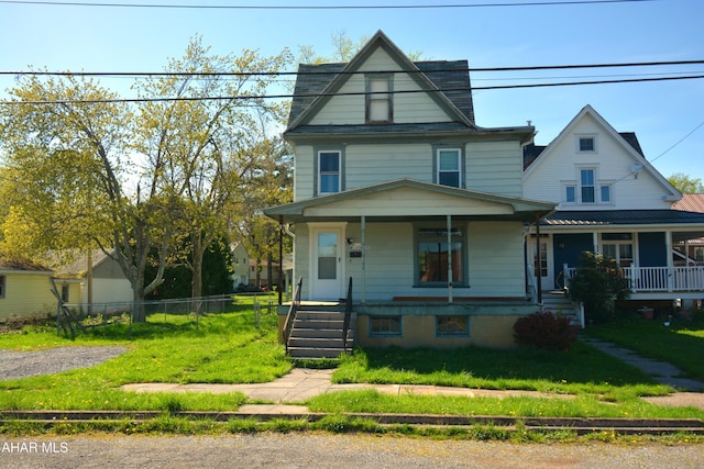 view of front of house featuring a porch, fence, and a front yard
