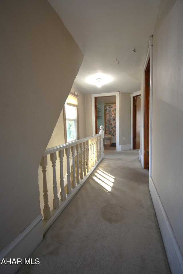 corridor with carpet and an upstairs landing