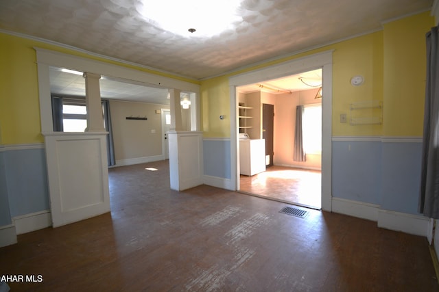 spare room with a wainscoted wall, decorative columns, wood finished floors, and visible vents