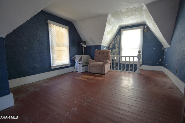 bonus room featuring baseboards, vaulted ceiling, and hardwood / wood-style flooring