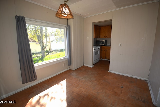 unfurnished dining area with crown molding, baseboards, and a wealth of natural light