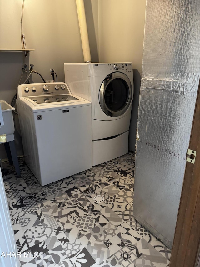 laundry room with light floors, cabinet space, and washing machine and clothes dryer