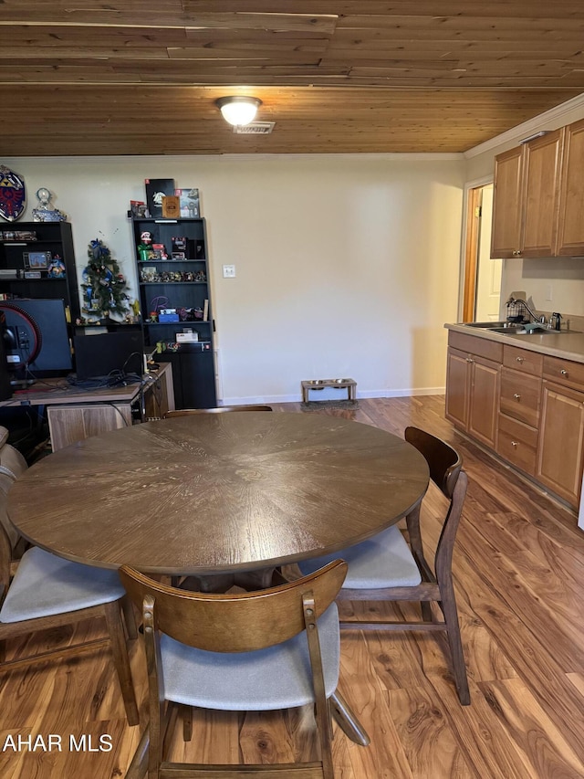 dining room featuring baseboards, visible vents, wooden ceiling, and wood finished floors
