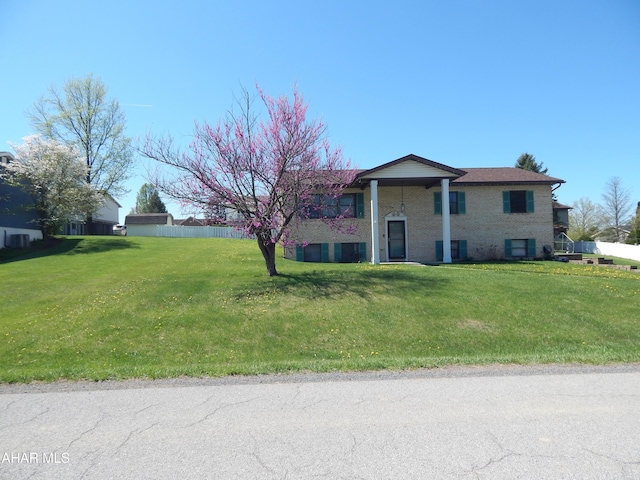 bi-level home with fence and brick siding