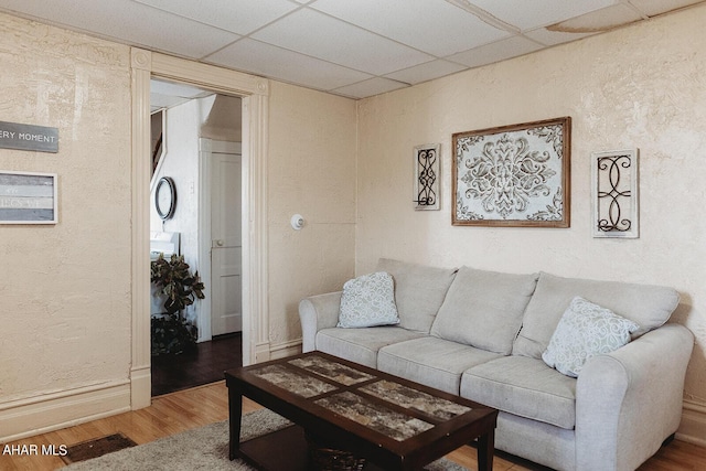 living room featuring hardwood / wood-style floors and a drop ceiling