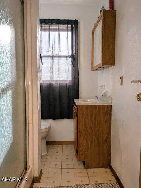 bathroom featuring vanity, toilet, and a shower with shower door