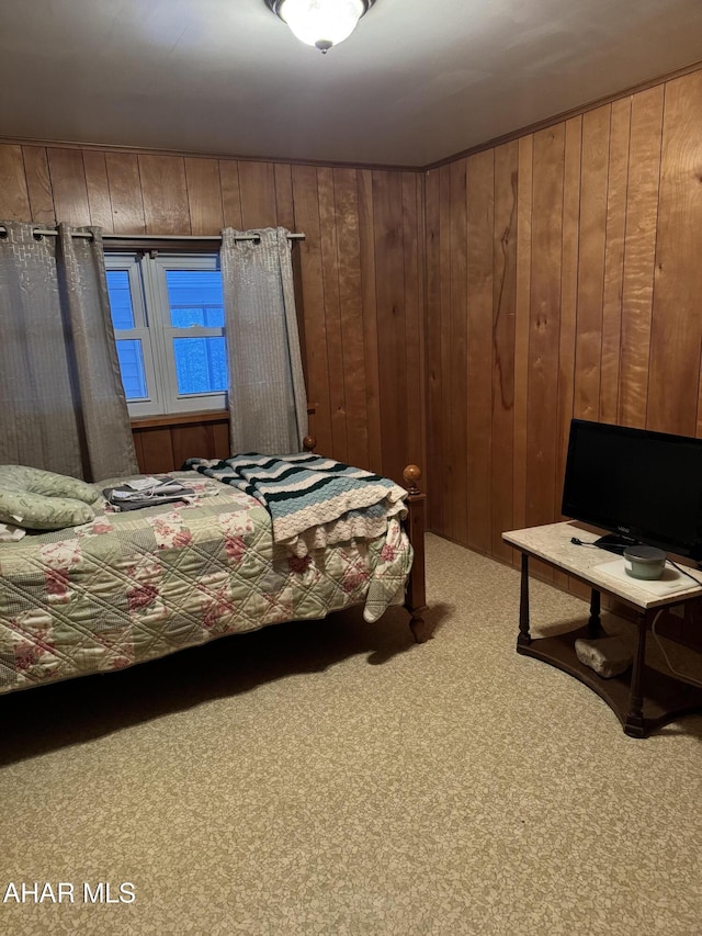 carpeted bedroom featuring wood walls