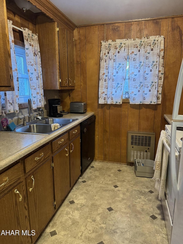 kitchen featuring dishwasher, sink, and wood walls