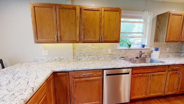 kitchen featuring dishwasher, sink, light stone counters, decorative backsplash, and hardwood / wood-style flooring