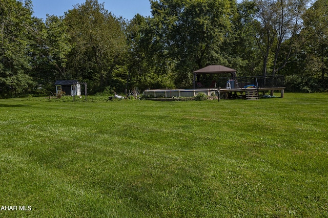 view of yard with a storage shed and a pool