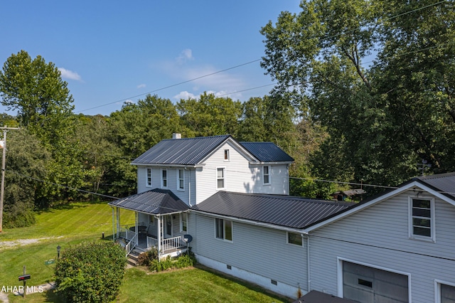 exterior space featuring a lawn, a garage, and covered porch