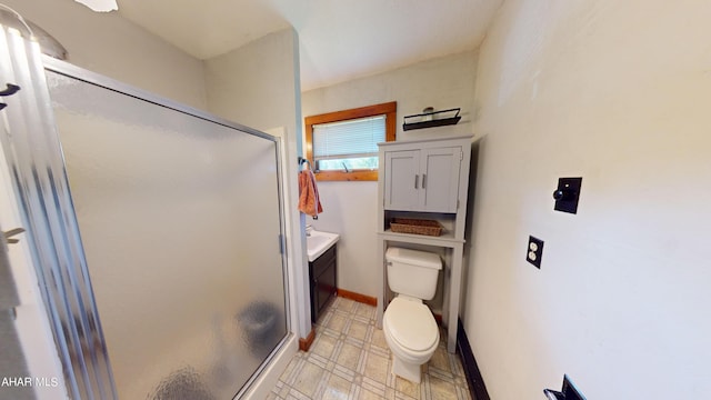 bathroom featuring vanity, toilet, and a shower with door