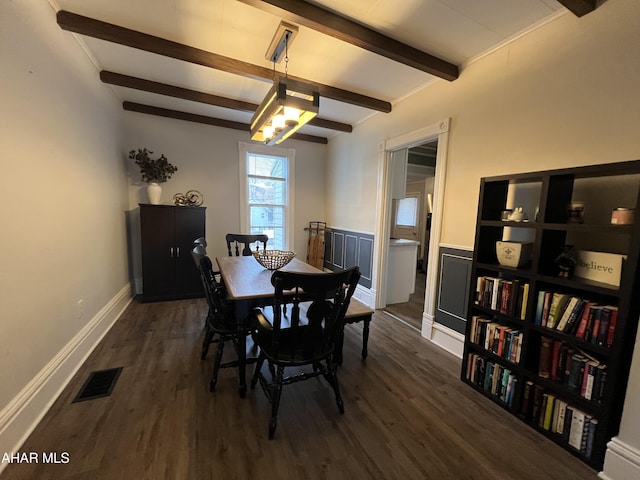 dining area with beamed ceiling and dark hardwood / wood-style flooring