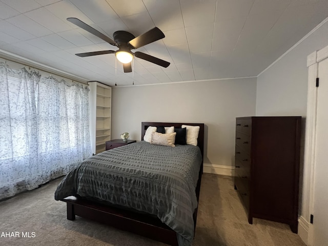 bedroom with carpet flooring, ceiling fan, and crown molding