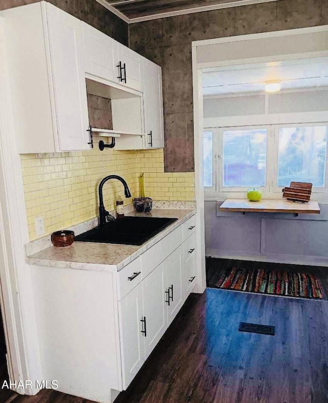 kitchen featuring white cabinets, dark hardwood / wood-style flooring, ornamental molding, and sink