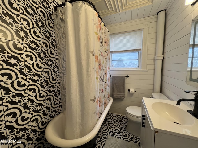 bathroom with tile patterned floors, vanity, toilet, and wooden walls