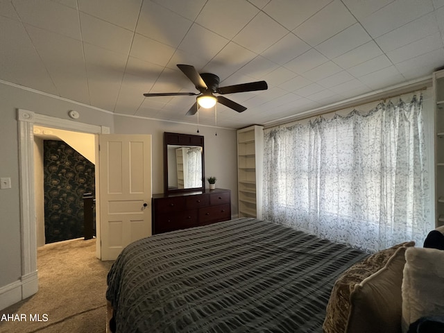 bedroom featuring light carpet, ceiling fan, and crown molding