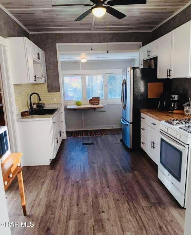 kitchen featuring white range with gas stovetop, sink, dark hardwood / wood-style floors, ornamental molding, and white cabinetry