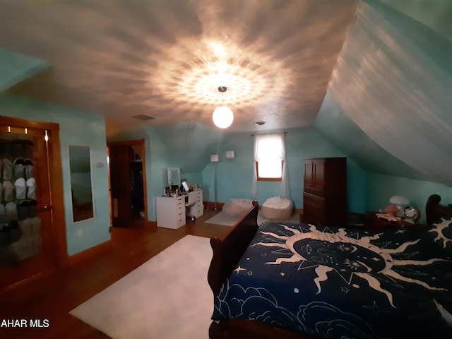 bedroom featuring vaulted ceiling and hardwood / wood-style flooring