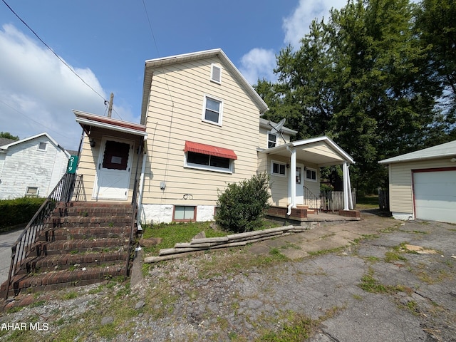 view of front of property with a garage and an outbuilding