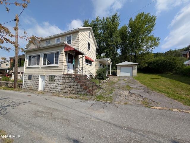 view of property featuring an outbuilding, a front yard, and a garage