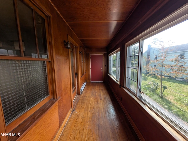 hallway featuring hardwood / wood-style floors, wood walls, wood ceiling, and baseboard heating