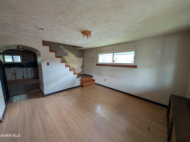 unfurnished room featuring a textured ceiling and light hardwood / wood-style floors