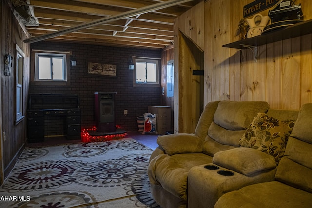 living room with wooden walls, brick wall, and a wood stove