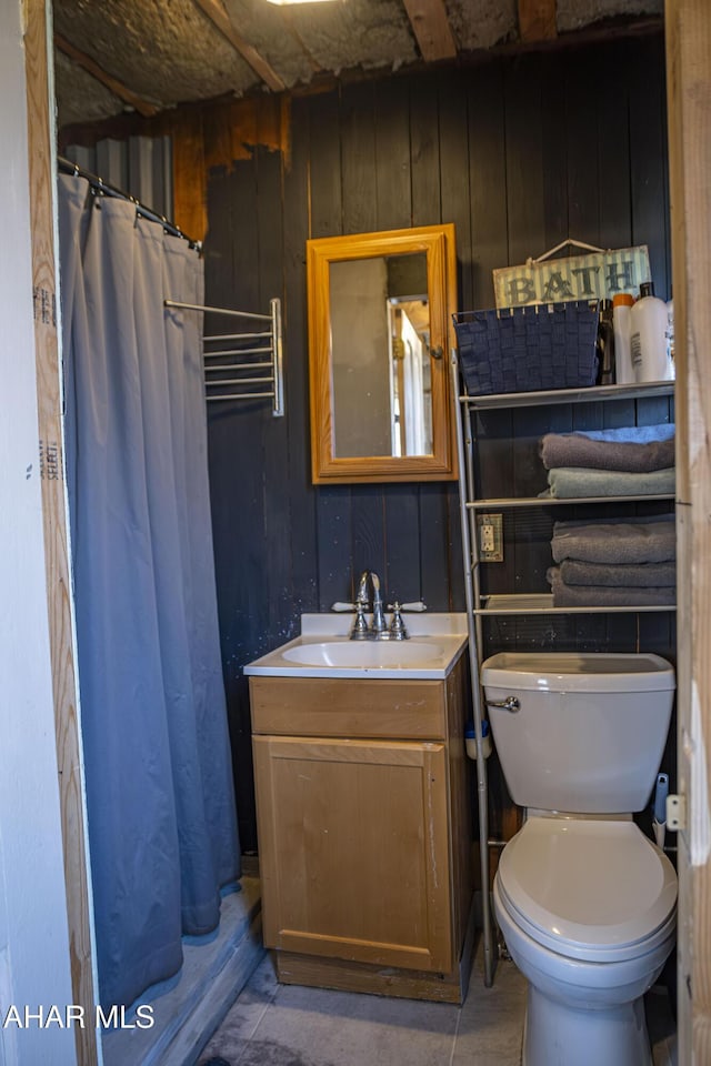 full bathroom with a shower with shower curtain, toilet, wood walls, and vanity