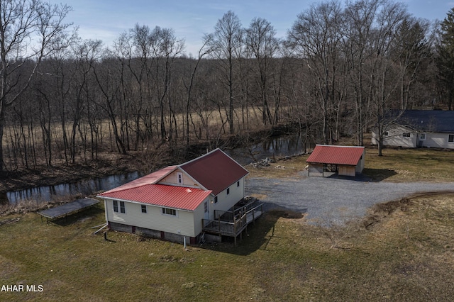 bird's eye view with a water view and a wooded view