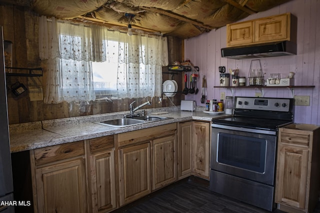 kitchen with light countertops, electric range, wooden walls, and a sink