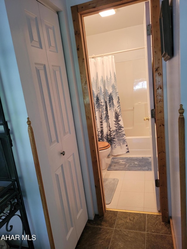 full bath featuring tile patterned flooring, toilet, and shower / tub combo with curtain