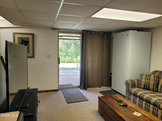 carpeted living room featuring a drop ceiling