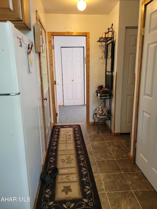 hall featuring dark tile patterned flooring