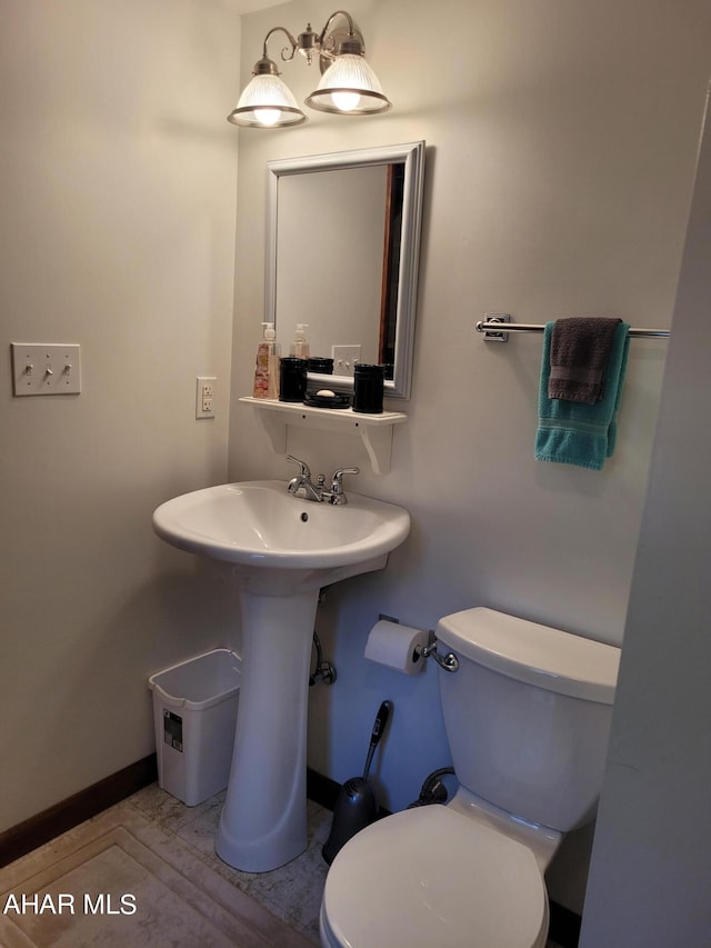 bathroom with toilet and baseboards