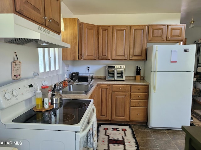 kitchen with white appliances, brown cabinetry, light countertops, under cabinet range hood, and a sink