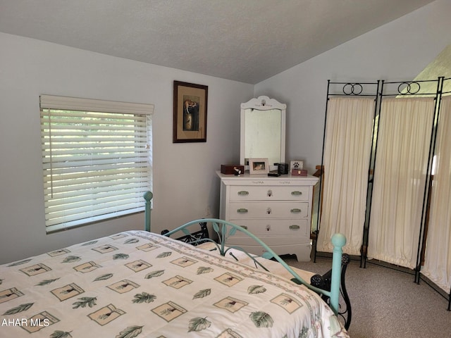 carpeted bedroom featuring vaulted ceiling and a textured ceiling