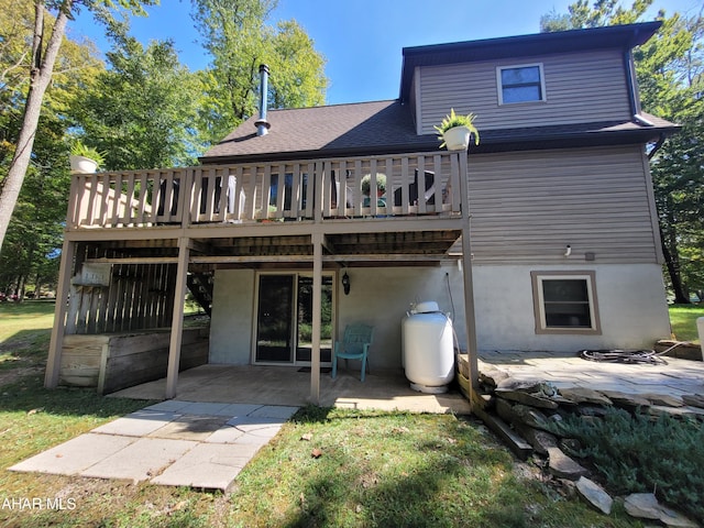 rear view of property with a patio, a shingled roof, and a wooden deck