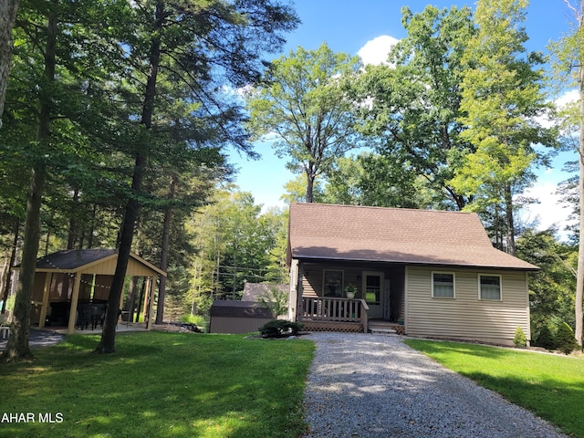 view of front of house featuring a front yard, covered porch, and driveway