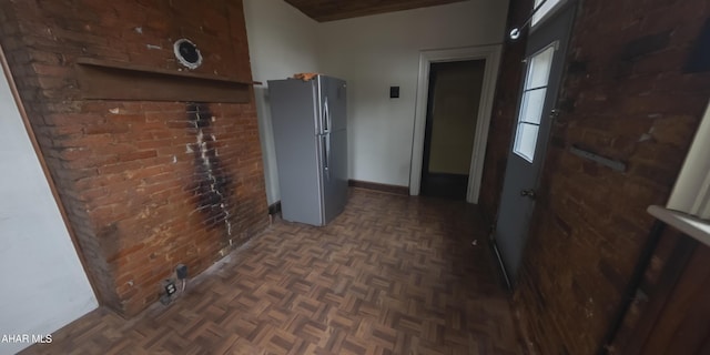 corridor with dark parquet floors and brick wall