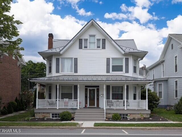 902 Main St, Saxton, PA 16678 - view of front facade featuring metal roof, a porch, a standing seam roof, and a chimney