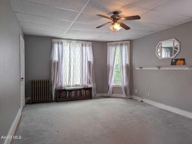 902 Main St, Saxton, PA 16678 - spare room featuring radiator heating unit, ceiling fan, carpet flooring, baseboards, and a drop ceiling