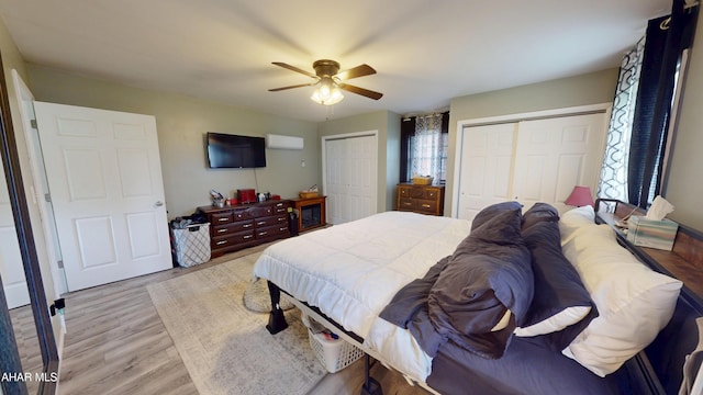 829 Ashcroft Ave, Cresson, PA 16630 - bedroom with two closets, light wood-type flooring, a wall mounted air conditioner, and ceiling fan