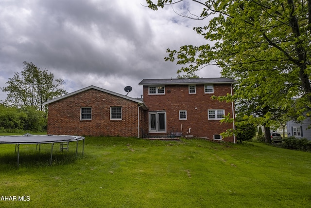 829 Ashcroft Ave, Cresson, PA 16630 - rear view of house with a trampoline, brick siding, and a lawn