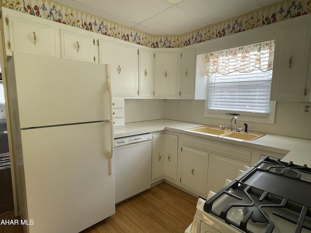 kitchen featuring light wood-type flooring, white appliances, sink, and white cabinets