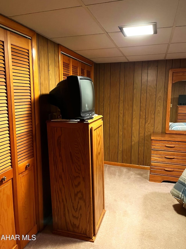 bar with light colored carpet, a paneled ceiling, and wood walls