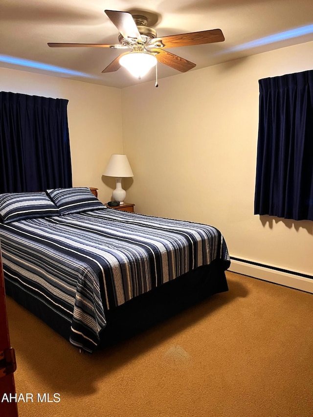 carpeted bedroom with ceiling fan and baseboard heating